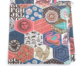 May include: A colorful fabric with a geometric pattern featuring a rooster, a sun, a clock, and letters of the alphabet. The fabric is made up of various shapes, including hexagons, squares, and triangles. The colors are bright and vibrant, including red, blue, green, yellow, and white.