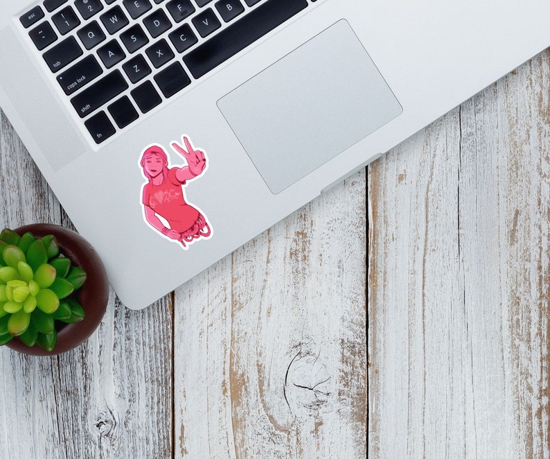 K&ouml;nnte beinhalten: Ein rosa Aufkleber mit einer Cartoon-Illustration einer Person, die ein Peace-Zeichen macht. Die Person tr&auml;gt ein rosa T-Shirt mit einem wei&szlig;en Design.