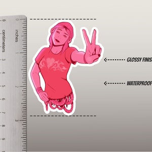 K&ouml;nnte beinhalten: Rosa-wei&szlig;er Sticker mit einer Cartoon-Frau mit rosa Haaren, die ein rosa Shirt mit Flammenmuster tr&auml;gt und ein Peace-Zeichen macht. Der Sticker hat eine gl&auml;nzende Oberfl&auml;che und ist wasserdicht.