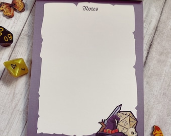 Op de afbeelding: Een paarse notitieboekje met een witte rand en het woord "Notes" bovenaan. Het notitieboekje heeft een cartoonillustratie van een tovenaarshoed, een zwaard en een 20-zijdige dobbelsteen in de rechterbenedenhoek.