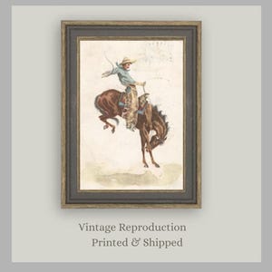 Antique Western art print featuring cowboy on bucking horse from “In the Saddle.” Rustic Americana artwork perfect for cowboy nursery décor, ranch-inspired homes, farmhouse walls, and vintage art collectors seeking Western heritage prints.