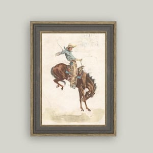 Framed reproduction of vintage cowboy and bucking horse artwork “In the Saddle.” Rustic Western wall décor for ranch homes, masculine office styling, cowboy nursery themes, and Americana art lovers. High-quality print of antique illustration