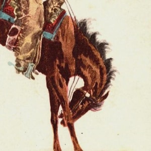 Close-up of vintage Western cowboy riding a bucking bronco, originally published as “In the Saddle.” Classic cowboy art perfect for Western home décor, ranch interiors, farmhouse walls, or collectors of vintage Americana illustrations