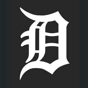 May include: A white stylized letter D with a black background. The letter is in a bold, gothic font.