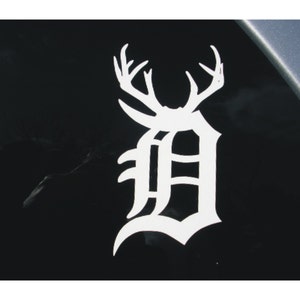 May include: White vinyl decal of a stylized letter "D" with antlers, resembling a deer head.