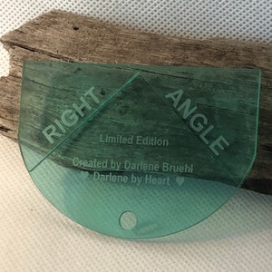May include: A green plastic right angle template with the words "RIGHT ANGLE" and "Limited Edition" printed on it. The template is created by Darlene Bruehl and has the text "Darlene by Heart" printed on it.