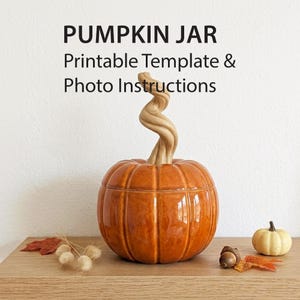 May include: A glossy orange ceramic pumpkin jar with a tall, twisted tan stem. The text PUMPKIN JAR Printable Template & Photo Instructions is displayed above the jar. A small white pumpkin, an acorn, and dried leaves are placed nearby.