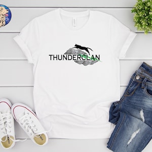 May include: White t-shirt with a black cat silhouette jumping on a gray cloud with the text "THUNDERCLAN" in black letters. A green line is drawn through the cloud.