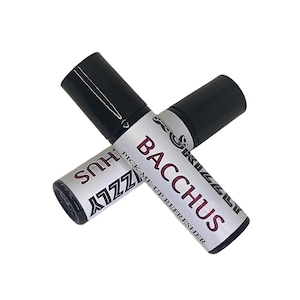 May include: Two black roll-on bottles with silver labels. The label on the top bottle reads "Pick-Me-Up Refresher" and "Bacchus". The label on the bottom bottle reads "Zizzy" and "Shus".