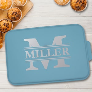 May include: A light blue baking pan with a silver monogram "M" and the name "MILLER" printed on it.