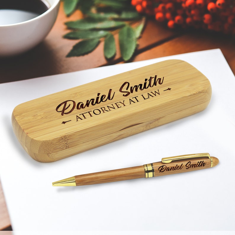 May include: A bamboo pen and case set with the name "Daniel Smith" and the text "Attorney at Law" engraved on the case.