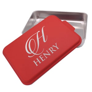 May include: Red baking pan with a lid. The lid has a white letter "H" and the name "HENRY" in a script font.