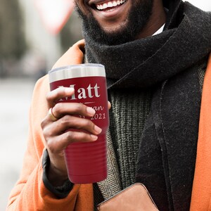 May include: A red stainless steel tumbler with a silver lid and a personalized inscription that reads "Matt - Jan 2021".