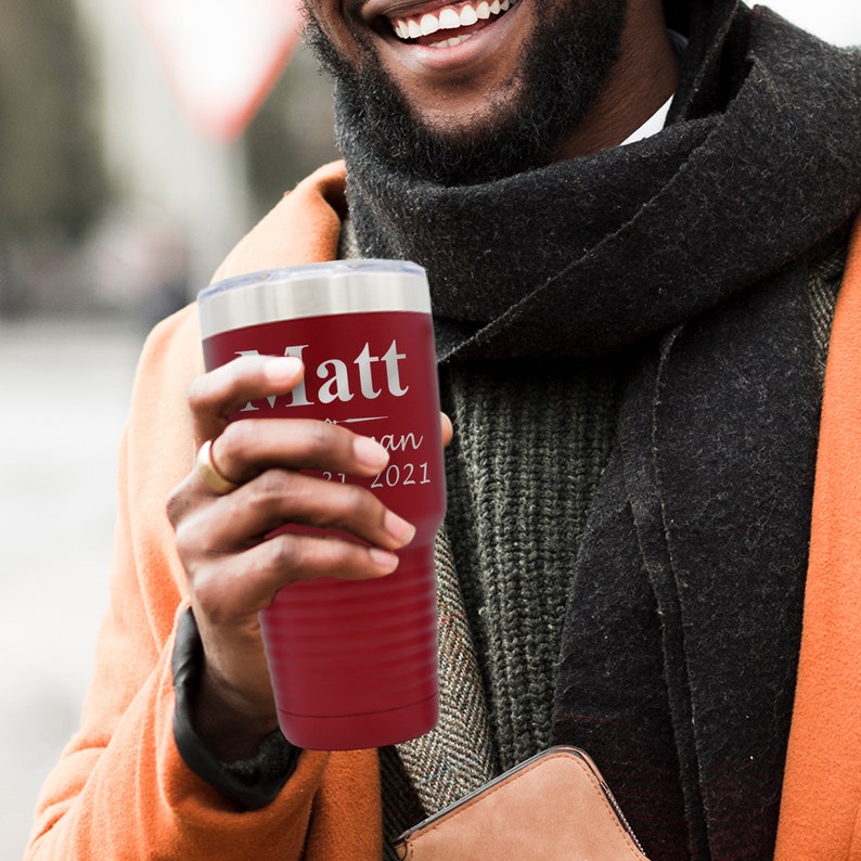 May include: A red stainless steel tumbler with a silver lid and a personalized inscription that reads "Matt - Jan 2021".