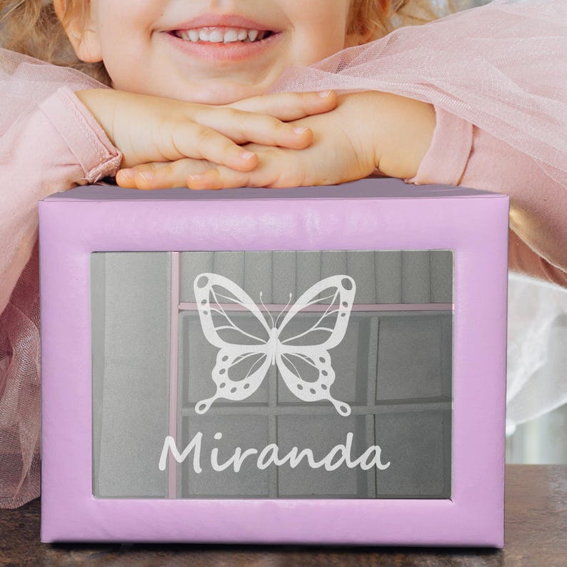 May include: A rectangular light purple storage box featuring a clear window on the front. The window displays a white graphic of a butterfly and the name Miranda printed in a white script font. The box has a smooth, solid-coloured exterior finish.