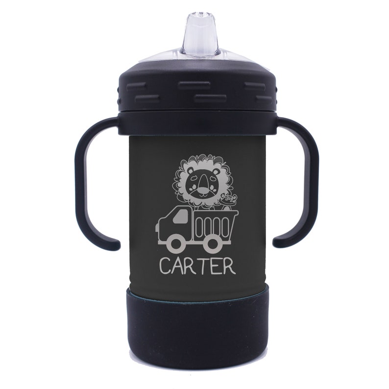 May include: Black and grey insulated toddler sippy cup with two handles. The cup features a lion riding in a dumper truck with the name "CARTER" printed below.