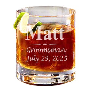 May include: A clear glass rocks glass with a lime wedge and brown liquid. The glass is engraved with the text "Matt Groomman July 29, 2025".