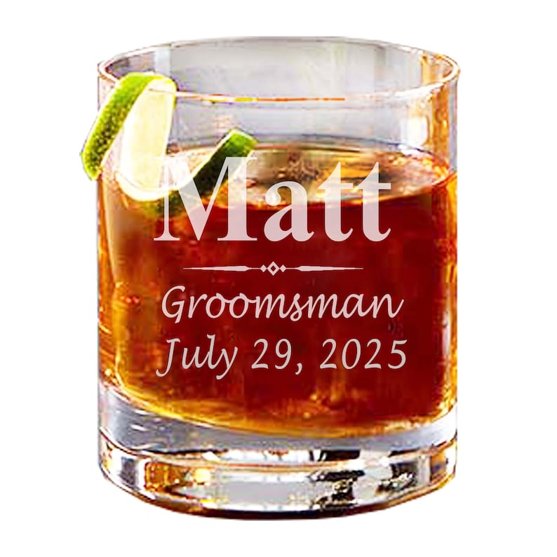 May include: A clear glass rocks glass with a lime wedge and brown liquid. The glass is engraved with the text "Matt Groomman July 29, 2025".