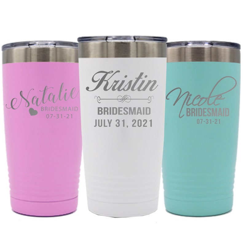 May include: Three stainless steel tumblers with personalised names and the word "bridesmaid" on each. The tumblers are pink, white and turquoise.