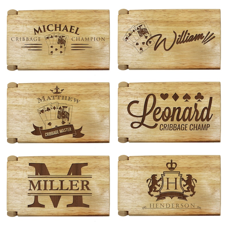 Puede incluir: Seis cajas de madera con diferentes grabados personalizados. Las cajas presentan nombres como "Michael", "William", "Matthew", "Leonard", "Miller" y "Henderson". Algunas cajas incluyen im&aacute;genes de cartas de juego y t&iacute;tulos como "Campe&oacute;n de Cribbage" y "Maestro de Cribbage".