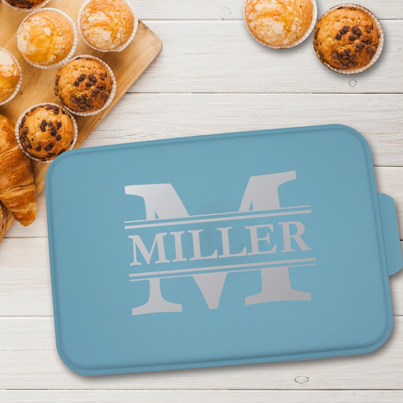 May include: A light blue baking pan with a silver monogram "M" and the name "MILLER" printed on it.