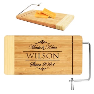 May include: Personalized bamboo cheese board with a built-in wire cheese cutter. The board is engraved with "Mark & Katie WILSON Since 2021".