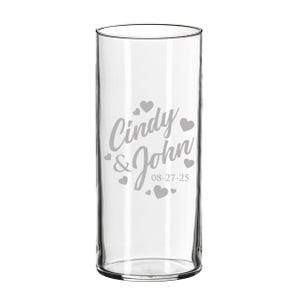 Op de afbeelding: Een cilindervormige vaas van helder glas met een gegraveerd ontwerp met de namen Cindy & John, de datum 08-27-25 en verschillende kleine hartvormen rondom de tekst. Het glas heeft een glad, transparant oppervlak en een rechte, verticale vorm.