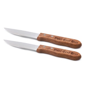 May include: Two stainless steel steak knives with wooden handles. The handles are engraved with the text "Your Text Here".