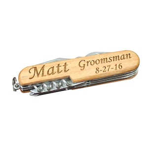 May include: A wooden pocket knife with a personalized inscription that reads "Matt  Groomsman 8-27-16".