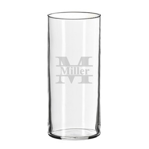 May include: A clear, cylindrical glass with a wide opening. The glass features an etched design of the letter "M" with the name "Miller" below it. The glass is suitable for beverages.