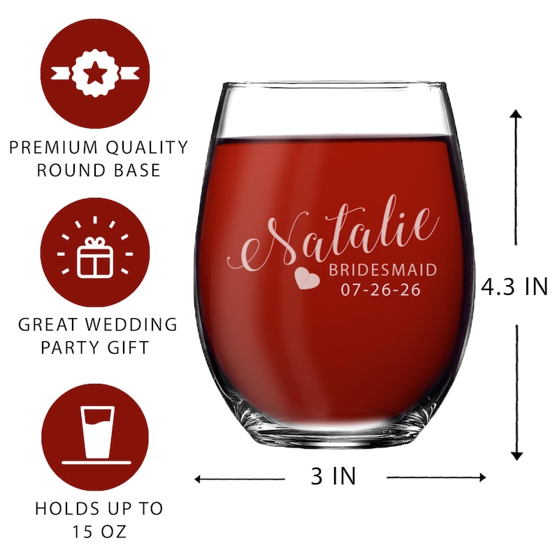 May include: A clear stemless wine glass filled with red liquid, featuring white text that reads Natalie, BRIDESMAID, and 07-26-26 with a small heart icon. The glass measures 4.3 inches in height and 3 inches in width, with a 15 ounce capacity.