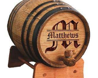May include: A wooden barrel with black metal bands and a wooden spigot. The barrel is engraved with the name "Matthews" and a decorative initial "M". The barrel rests on a wooden stand.