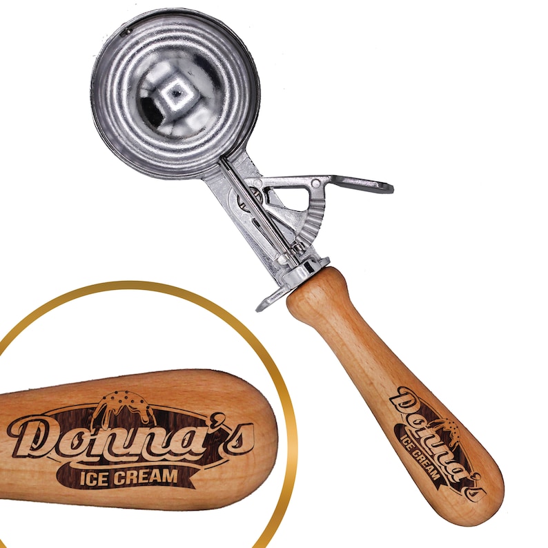 May include: A silver ice cream scoop with a wooden handle. The handle is engraved with the words "Donna's Ice Cream".
