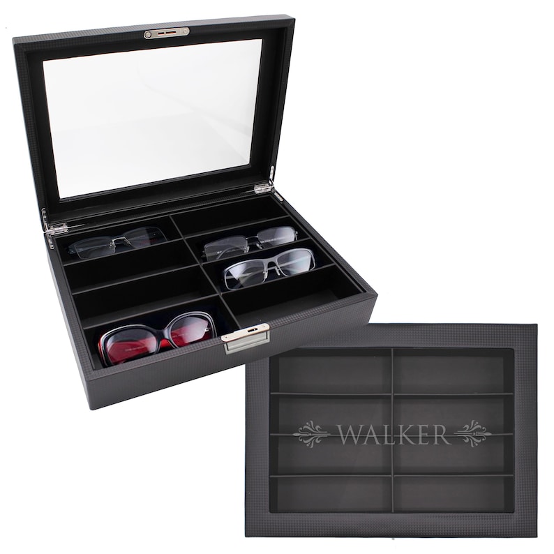 May include: A black rectangular eyewear storage case with a clear glass lid and a silver metal latch. The interior features eight individual compartments lined in black fabric. The lid is engraved with the name WALKER and decorative flourishes.