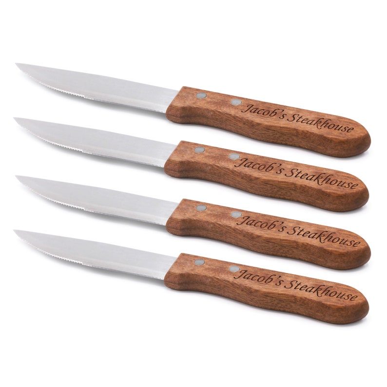 May include: Set of four steak knives with wooden handles. Each handle is engraved with "Jacob's Steakhouse".