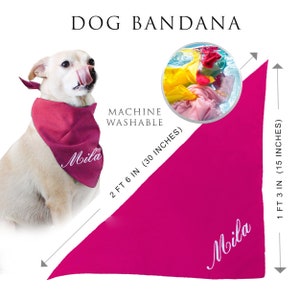 May include: A bright pink triangular dog bandana featuring the name Mila in white script. The bandana measures 30 inches by 15 inches and is labeled as machine washable. A dog is shown wearing the bandana, and a circular inset shows it in water.