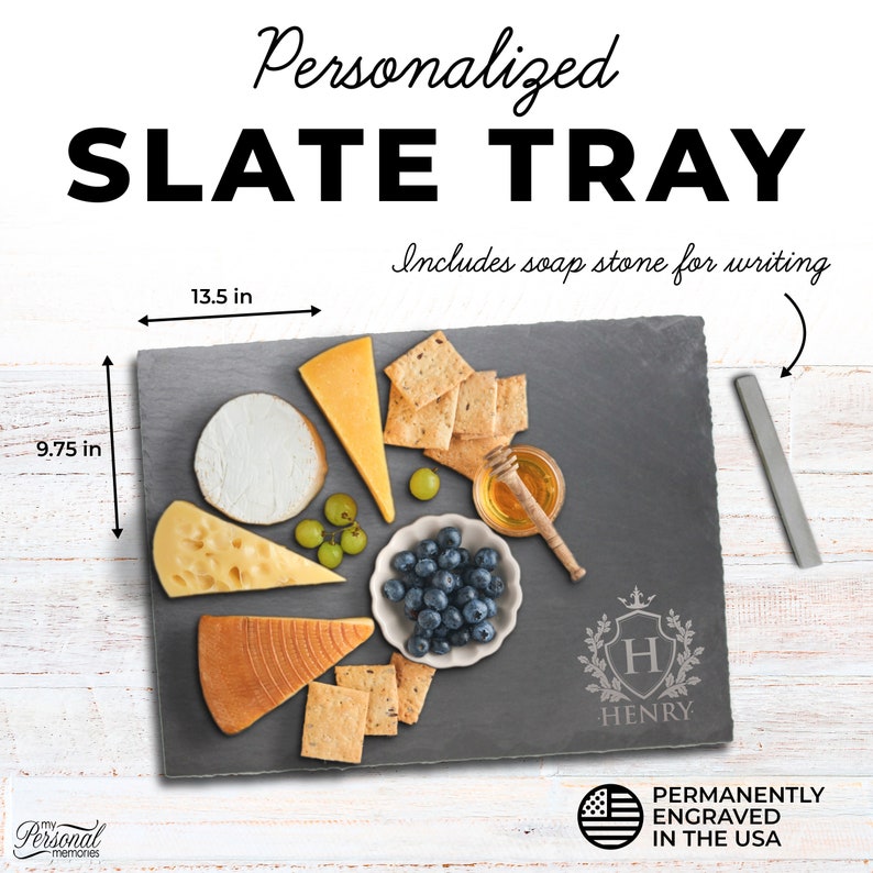 May include: A rectangular dark gray slate tray measuring 13.5 inches by 9.75 inches, featuring an engraved crest with the letter H and the name HENRY. It includes a soapstone for writing and is displayed with assorted cheeses, crackers, and fruit.