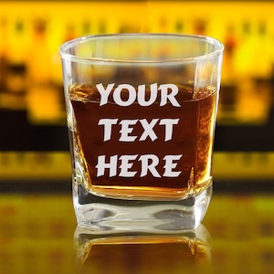 May include: A clear glass with a square base filled with amber liquid. The glass has the words "YOUR TEXT HERE" etched into the side.