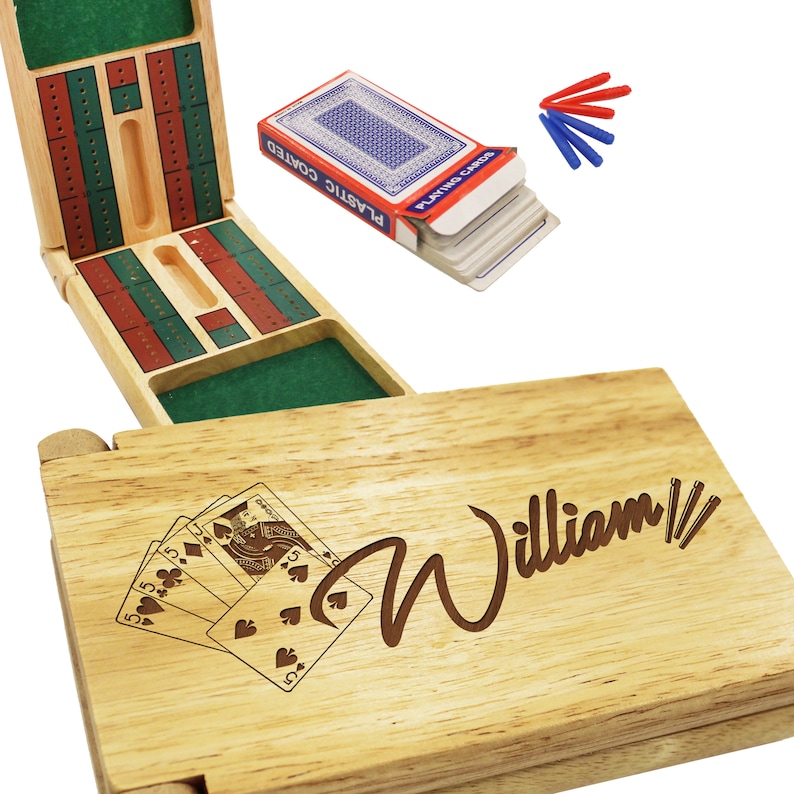 Puede incluir: Un juego de cribbage de madera con una inscripci&oacute;n personalizada que dice "William". El juego incluye una caja de madera con una superficie de juego de fieltro verde, una baraja de cartas y fichas de puntuaci&oacute;n.