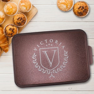May include: A brown baking sheet with a raised edge and a silver embossed design that says "VICTORIA" with a crest and a "V" inside.