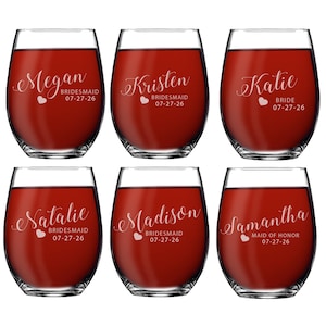May include: Six clear stemless wine glasses filled with red liquid. Each glass features white script text with names Megan, Kristen, Katie, Natalie, Madison, and Samantha, along with titles like BRIDESMAID, BRIDE, or MAID OF HONOR and the date 07-27-26.