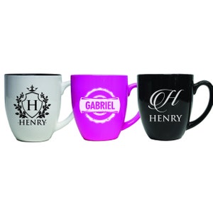 Pu&ograve; includere: Tre tazze in ceramica con manico. La tazza a sinistra &egrave; bianca con uno stemma nero, la lettera H e il nome HENRY. La tazza centrale &egrave; rosa acceso con un emblema circolare bianco e il nome GABRIEL. La tazza a destra &egrave; nera con una H in corsivo bianco e HENRY.
