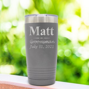 May include: Gray stainless steel tumbler with the name "Matt" engraved, along with the words "Groomsman" and "July 31, 2021".