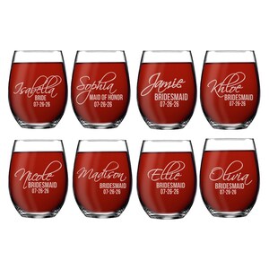 May include: Eight stemless wine glasses filled with red liquid, each featuring white etched text. The names Isabella, Sophia, Jamie, Khloe, Nicole, Madison, Ellie, and Olivia are displayed with titles like Bride, Maid of Honor, and Bridesmaid, plus 07-26-26.