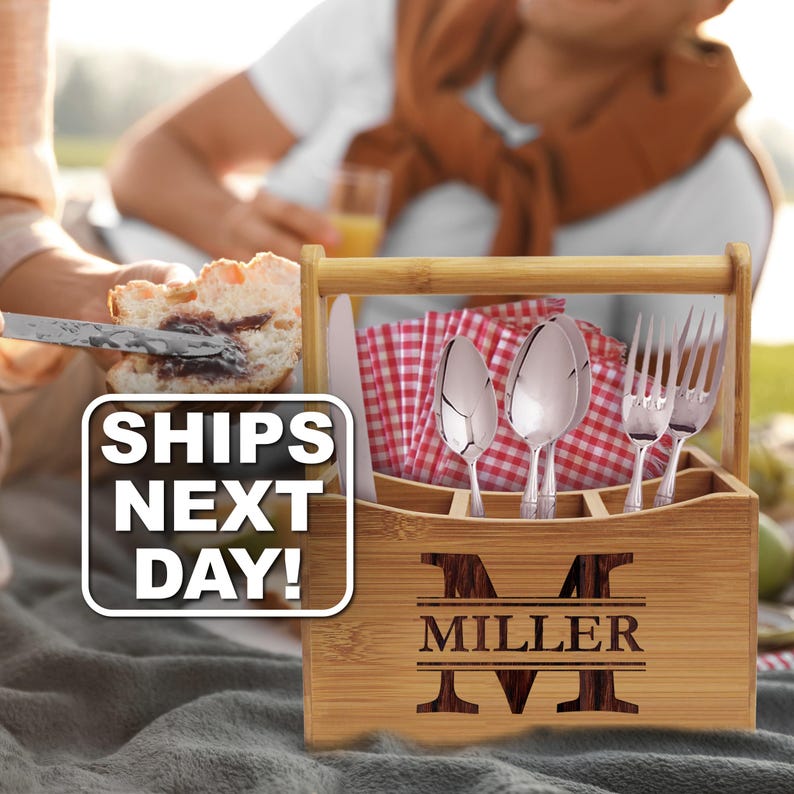 May include: A rectangular bamboo utensil caddy with a handle, featuring the engraved letter M and the name MILLER on the front. The caddy holds silver-toned spoons, forks, and a knife, along with red and white checkered napkins. Text reads SHIPS NEXT DAY!