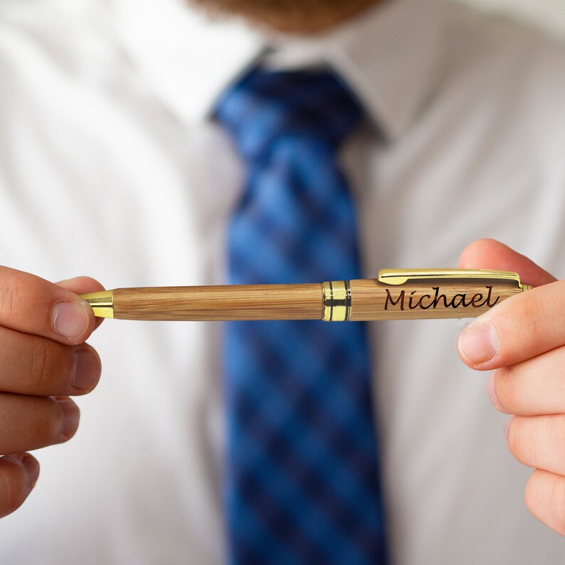May include: A wooden pen with a gold trim and the name "Michael" engraved on it.