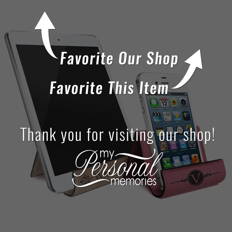 May include: Two cell phone stands, one for a tablet and one for a smartphone, both made of brown leather with a pink leather insert. The tablet stand has a white tablet in it and the smartphone stand has a black smartphone in it. The text "my Personal memories" is on the tablet stand.