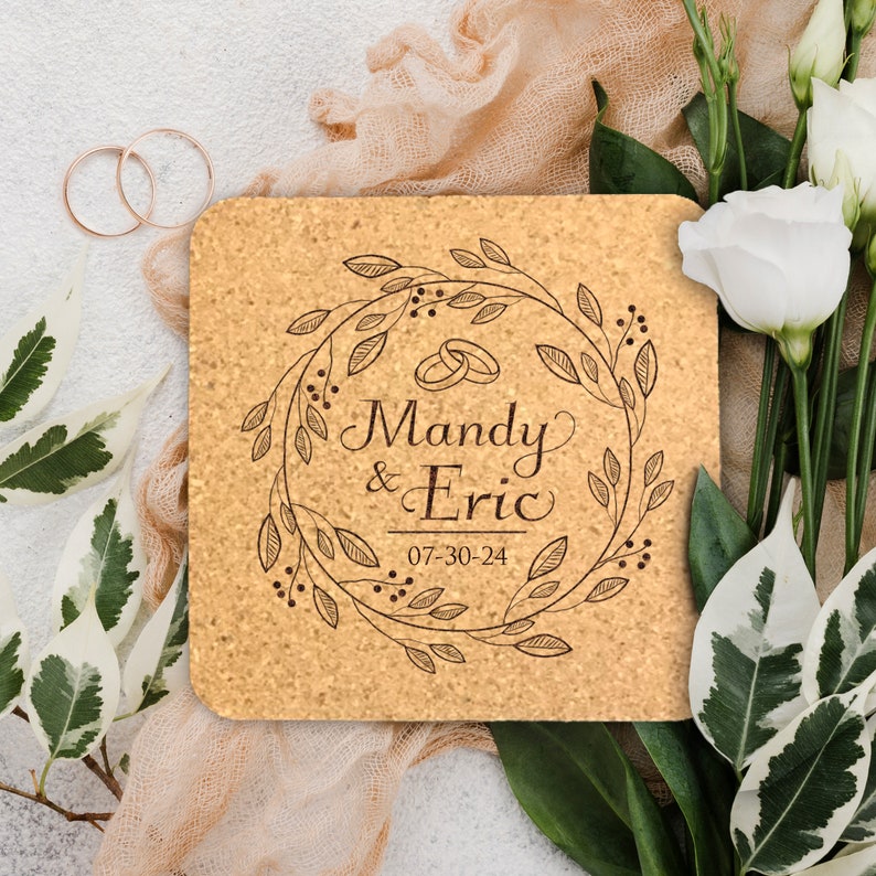 May include: A cork coaster with a brown floral wreath design, the names Mandy & Eric, and the date 07-30-24 engraved in the center.