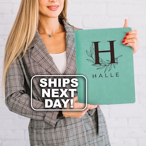 May include: A rectangular mint green portfolio folder featuring a large dark brown letter H centered within a decorative leaf wreath design, with the name HALLE printed in dark brown capital letters directly underneath the letter H.