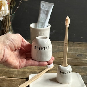 individual ceramic toothbrush holder with personalized name engraved and glazed in black, shiny white toothbrush holder